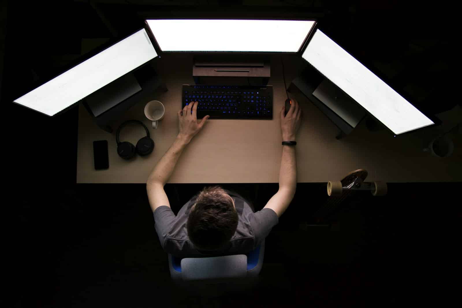 Engineer building a production-grade AI agent at a multi-monitor workstation