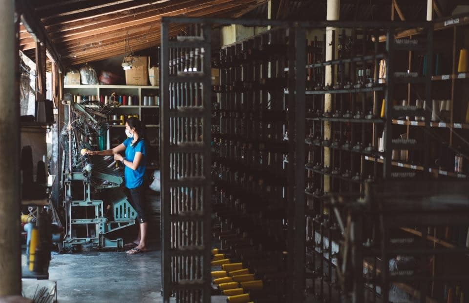 Worker among tall warehouse racking
